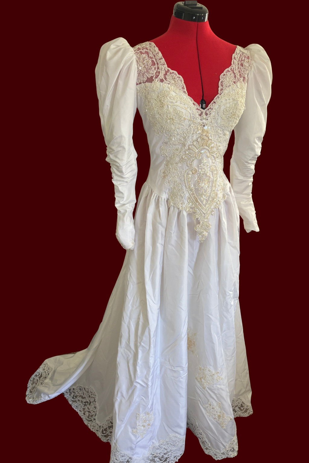 White lace dress on a mannequin against a red background