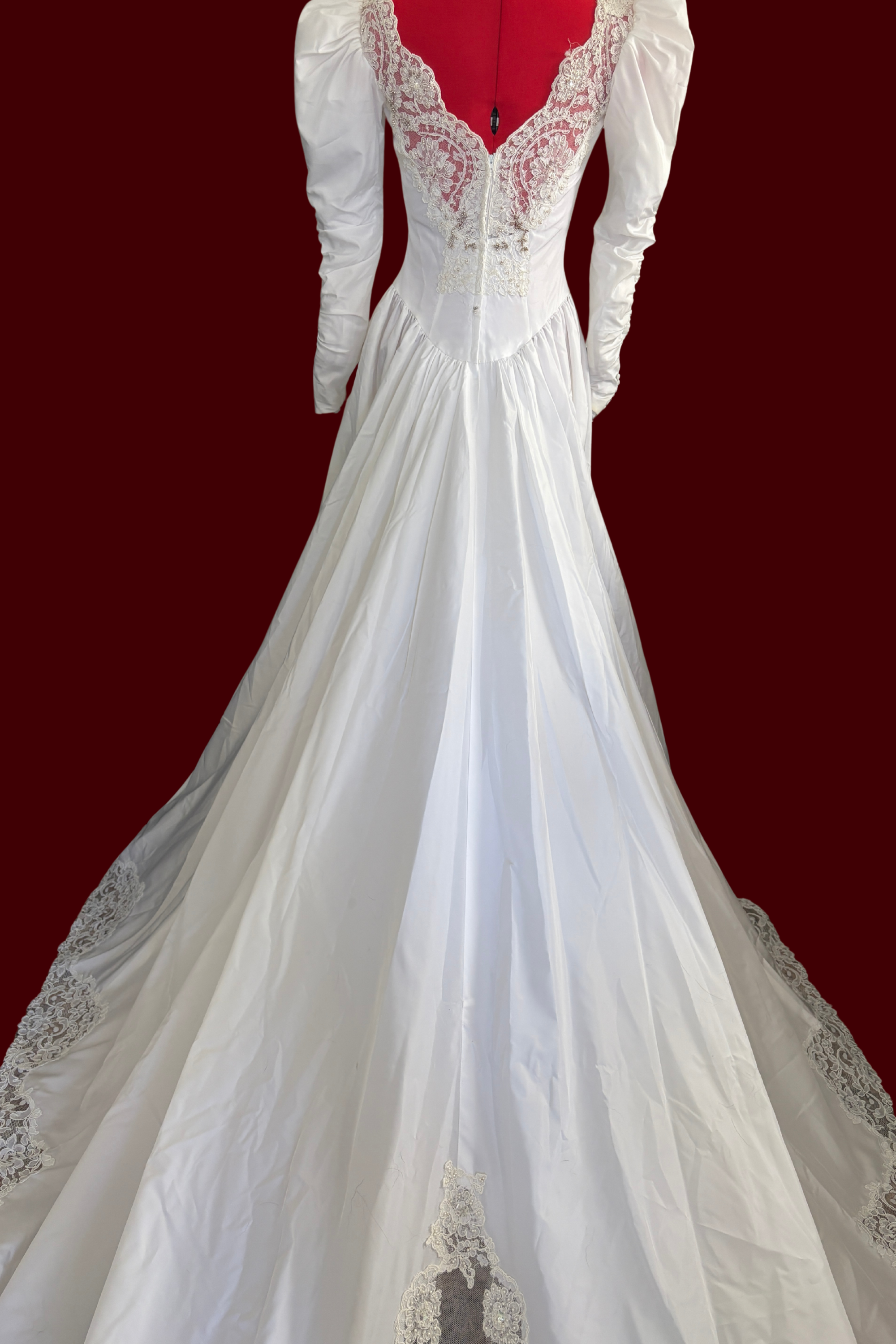 White wedding dress with lace details on a red background